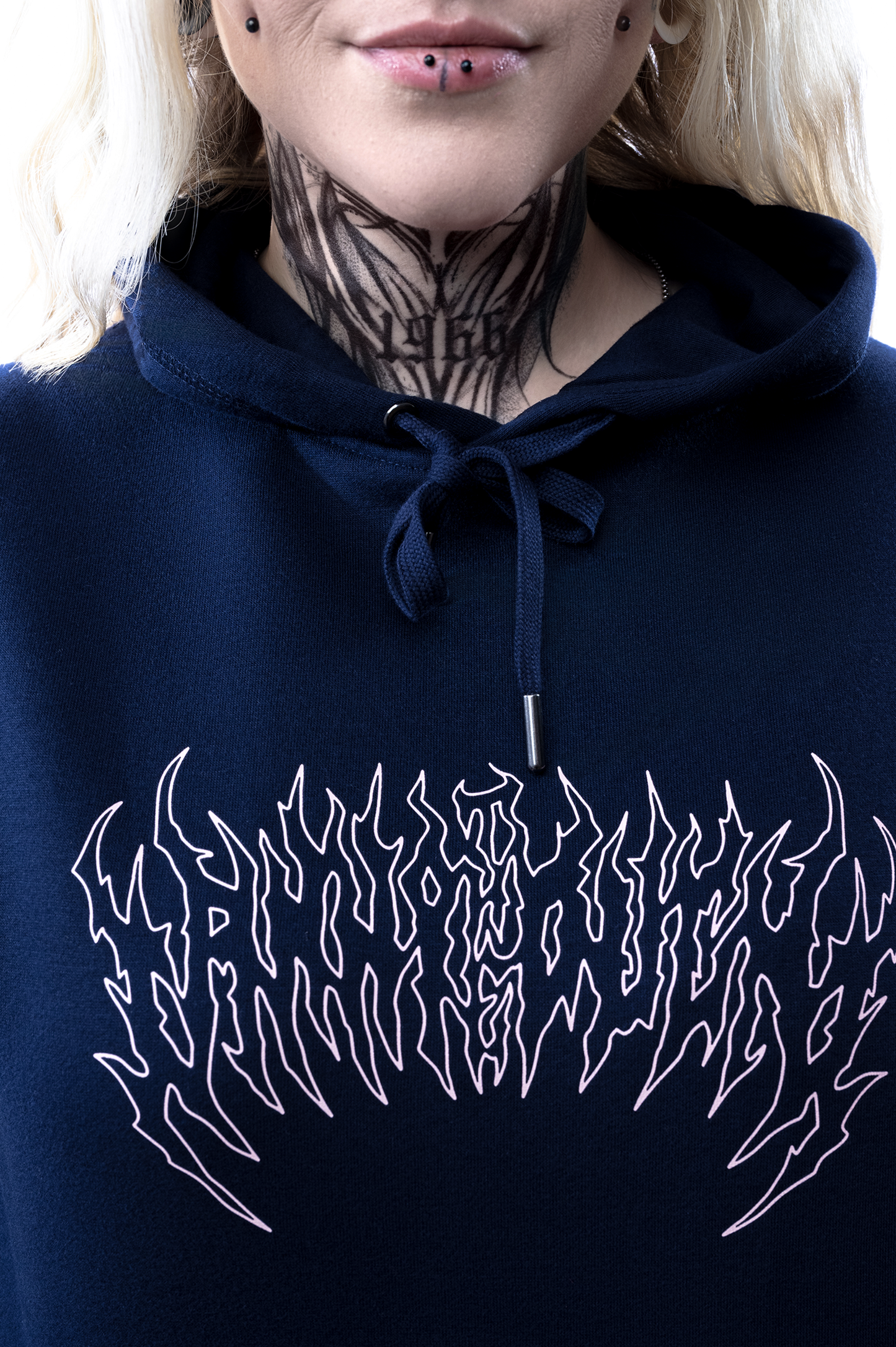 Nahaufnahme des weißen Frontprints in flammenartiger Typografie auf dem dunkelblauen Hoodie, Kapuzenbändel mittig sichtbar.