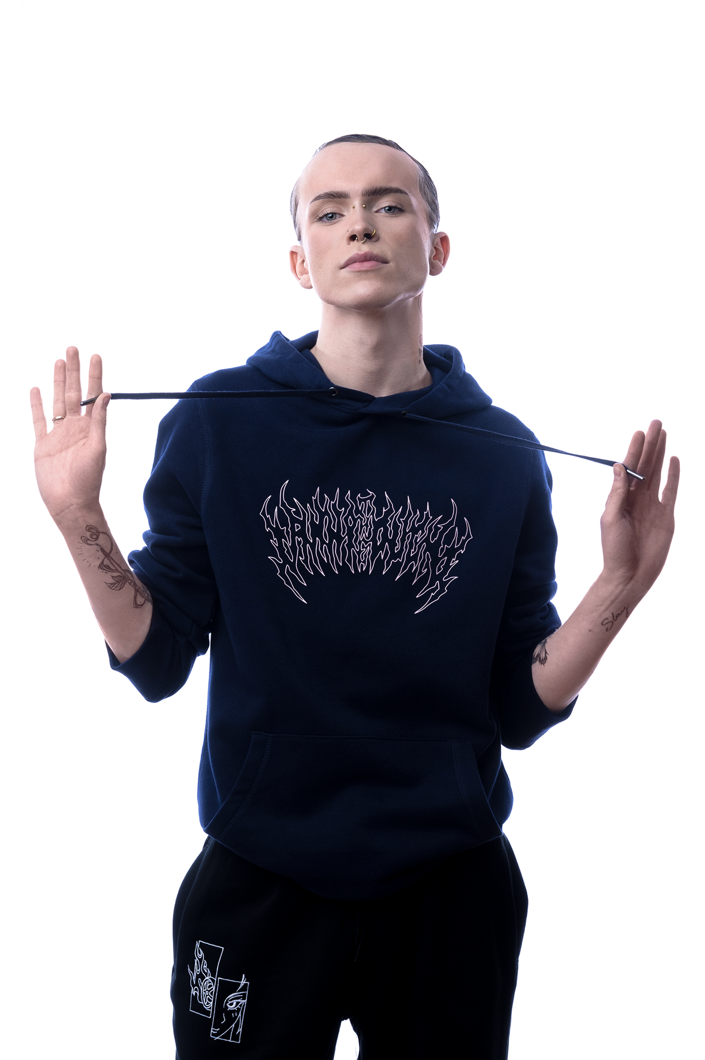 Person mit glattem Haar trägt den dunkelblauen Hoodie mit weißem Frontprint, hält die Kapuzenbänder locker seitlich.