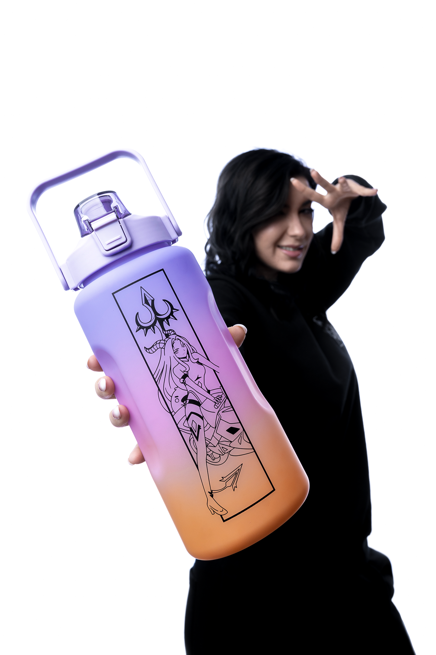 Frau mit schwarzem Hoodie präsentiert eine große Trinkflasche mit Lila-zu-Orange-Verlauf und schwarzem Flammendesign sowie einem stilisierten Dreizack. Die Flasche wird in den Vordergrund gehalten, während die Frau im Hintergrund unscharf ist.
