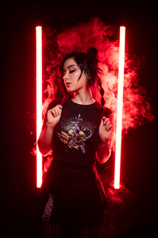 Schwarzes T-Shirt mit kräftigem Print einer weiblichen Figur auf Motorrad vor Flammenhintergrund; getragen von einem Model in dramatischer Lichtszene mit Nebel.
