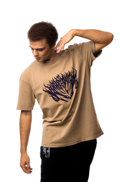Locker sitzendes T-Shirt in Braun mit violettem Print, getragen von einer Person in Bewegung mit erhobenen Armen.