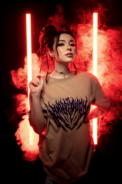 Das braune T-Shirt mit Flammenprint wird vor rot leuchtendem Hintergrund von einer Person mit Zöpfen getragen.