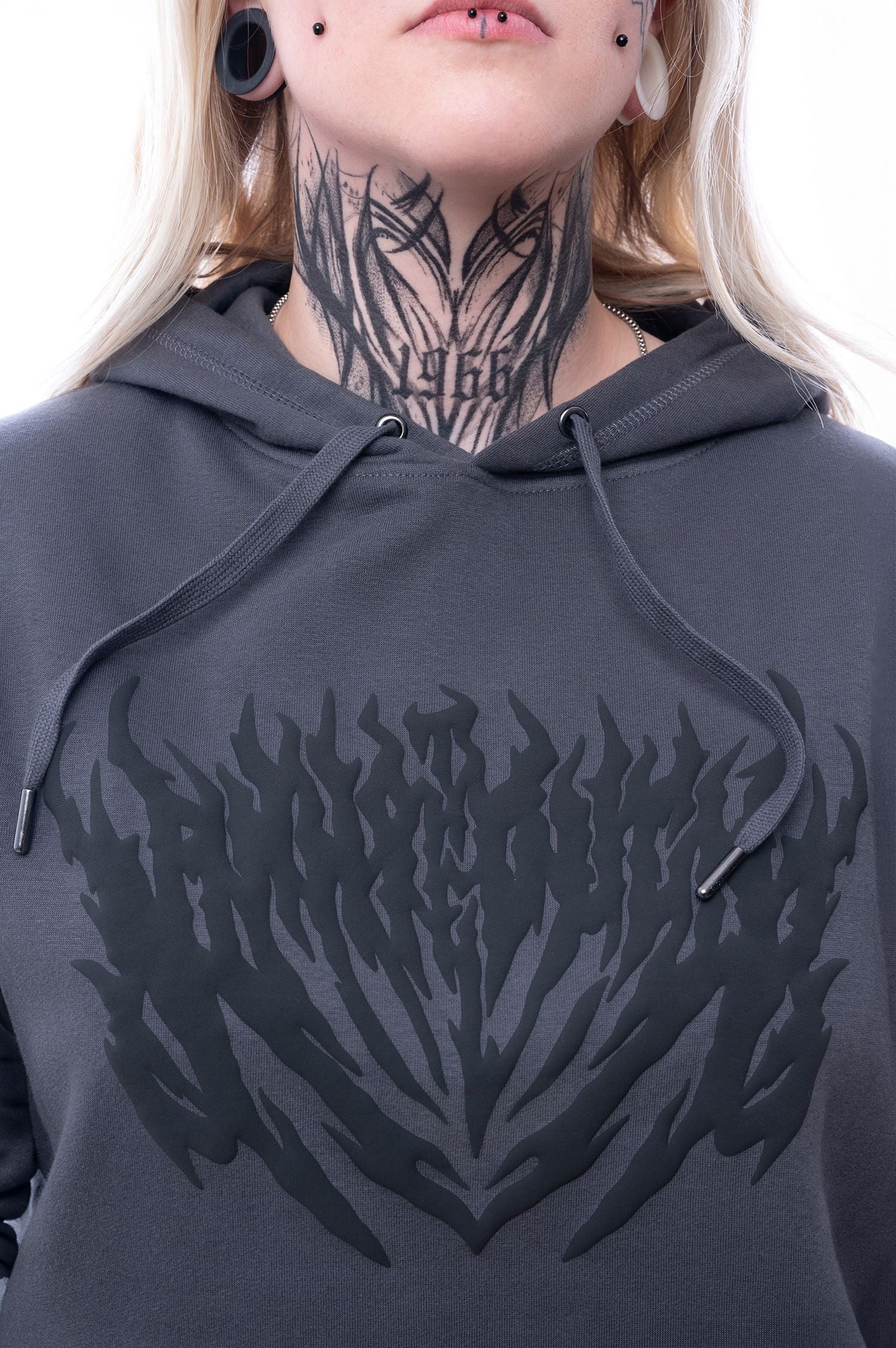 Detailansicht des schwarzen, flammenartigen Frontprints auf dem dunkelgrauen Hoodie. Die Textur des Drucks ist leicht erhaben und glänzend.