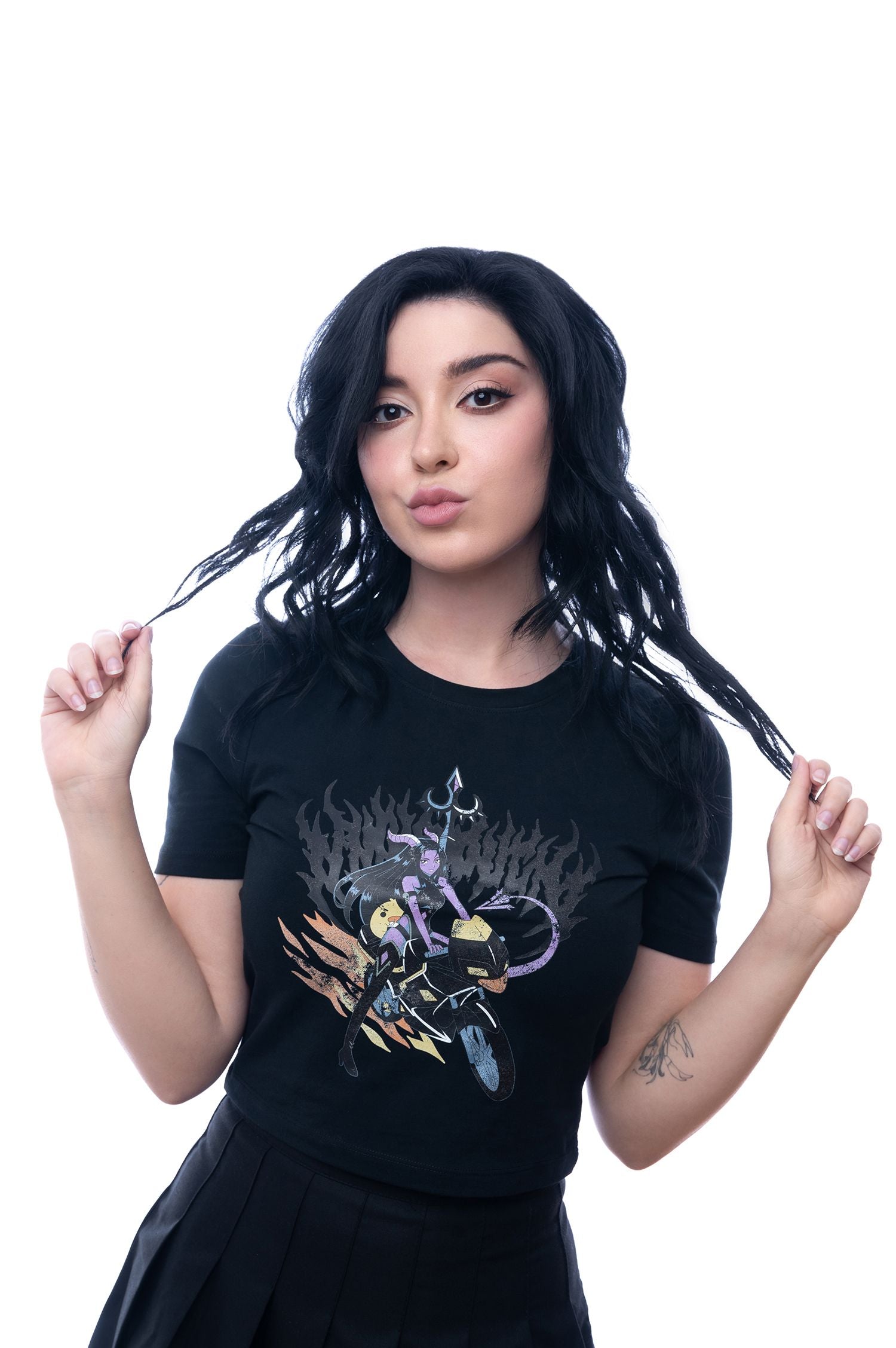 Shirt mit detailliertem Anime-Print, getragen in weißem Studio-Setting; Model greift verspielter Pose in die Haarspitzen, Fokus auf Oberkörper und Shirt.