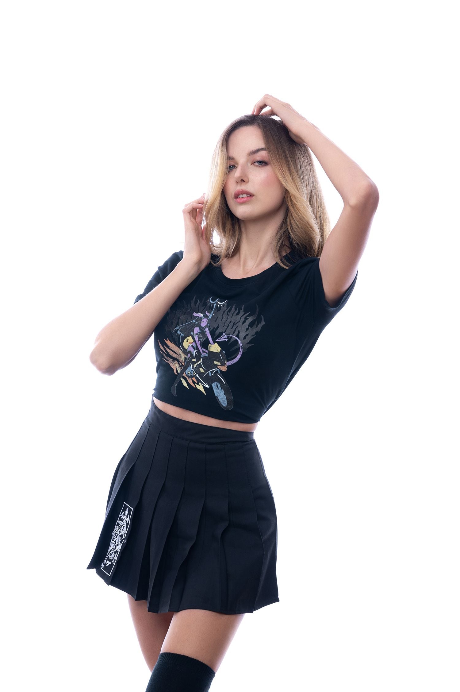 Shirt mit detailliertem Anime-Print, getragen in weißem Studio-Setting; Model greift verspielter Pose in die Haarspitzen, Fokus auf Oberkörper und Shirt.