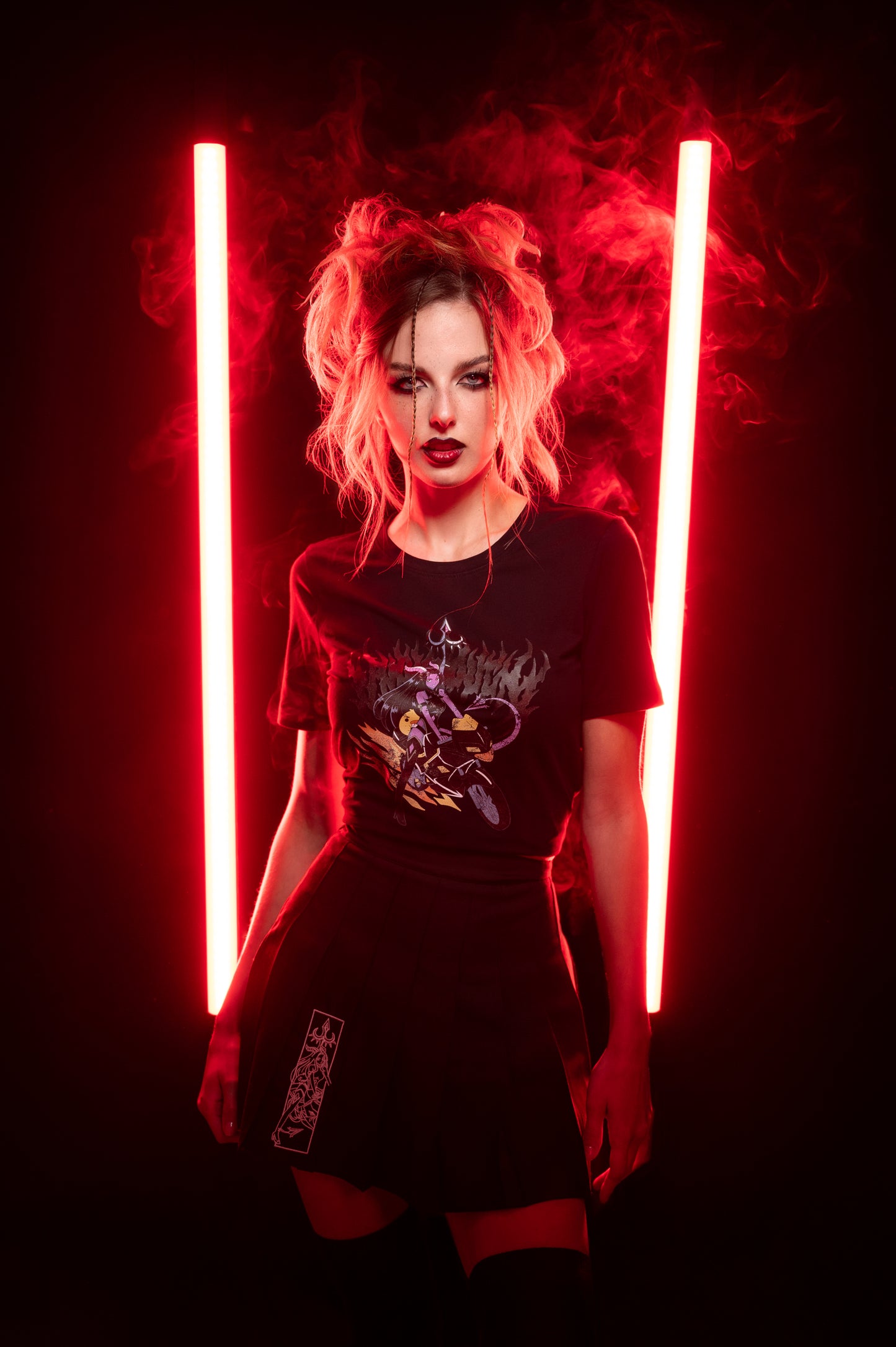 Schwarzes Anime-T-Shirt in Cropped-Form mit leuchtendem Druckmotiv, getragen von einem Model mit voluminösem Hairstyling und dunklem Lippenstift; rote Lichtumgebung.